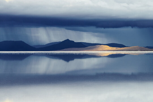 Rain falling over the mountains beyond the Salar de Uyuni, Bolivia