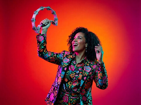 Joyful Musician with Tambourine in Colorful Jacket