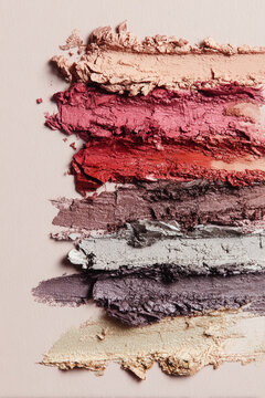 Layered beauty product swatches showing various makeup colors and textures, ideal for cosmetics and fashion concepts