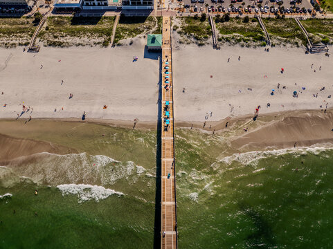 Aerial top-down view of Jacksonville Beach Pier with waves and beachgoers, Florida June 28, 2026