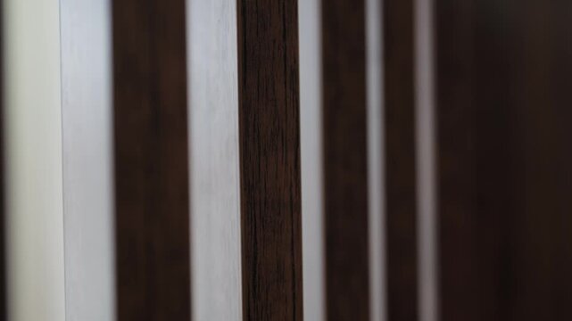 Beautiful abstract background featuring alternating dark brown wooden and white vertical slats with a smooth focus pull effect, creating a dynamic and modern geometric pattern for design projects