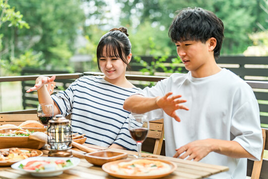 A couple is having trouble with insect bites while eating outdoors.