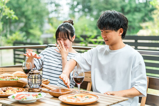 A couple is having trouble with insect bites while eating outdoors.