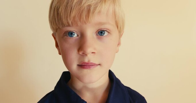 Little blond boy making funny faces and smiling toothlessly