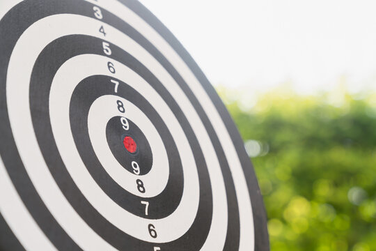 Dartboard stands tall and get someone skilled to throw darts, concept for business target planning growth and aim to winner goal.