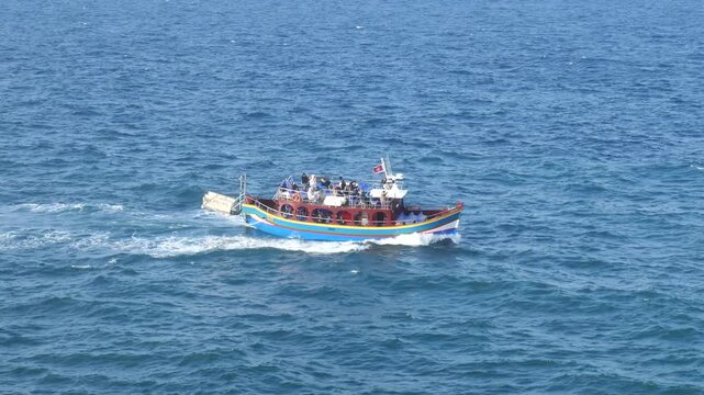 traditional maltese luzzu boat grand harbour valletta malta tourists aboard colorful hull maltese flag cruising mediterranean sea harbour tour grand harbour sightseeing boat tour valletta harbour