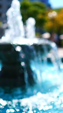 A Serene Water Fountain with Cascading Water in a Blurry Urban Setting, Capturing the Essence of Relaxation and Tranquility in a Public Space