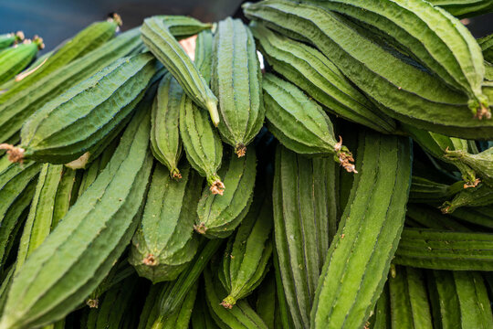 Angled luffa (Chinese okra) piled at a farmers market stall
