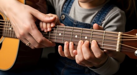 Fototapeta premium Mother teaching her child how to play acoustic guitar at home