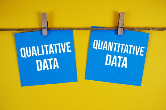 Qualitative Data Vs Quantitative Data paper notes hanging on the rope with clothespins