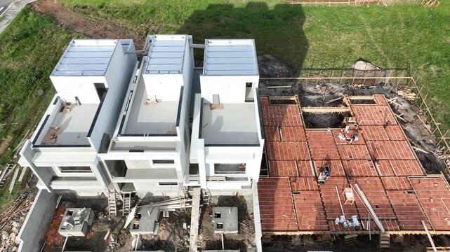Aerial view of a construction site with workers installing pre-cast concrete and brick flooring for modern housing in Florianopolis, Santa Catarina, Brazil.