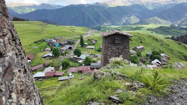 Medieval stone tower overlooking a village in the georgian mountains