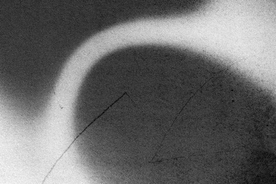 Abstract black and white grainy texture featuring a soft bright elongated streak and scattered speckles, ideal as a photography background, design asset, or creative texture