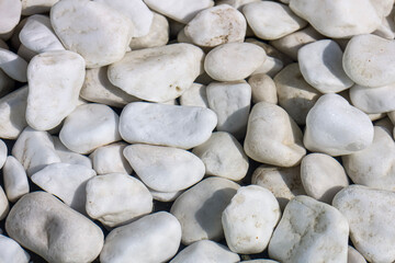 Smooth white pebbles and stones create a textured natural background © Діма Осташук