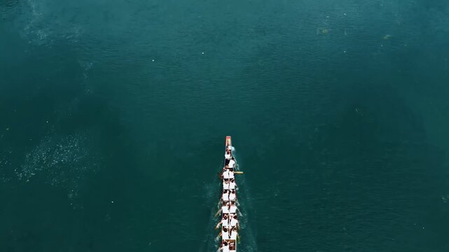 Top‑down aerial drone view of traditional Chinese dragon boat race on river, Dragon Boat Festival cultural event 4K