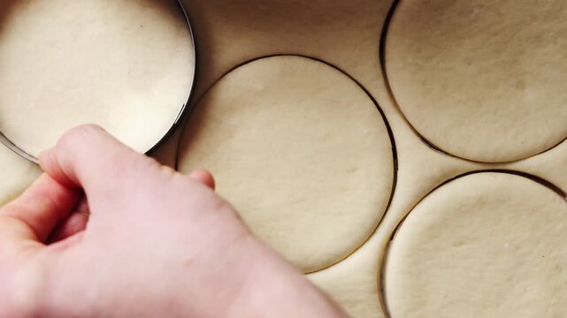 Metal ring cutter shapes pierogi dough circles. Pierogi dough wraps potato, cheese, mushroom, cabbage or meat fillings. Boil or fry pierogi dough parcels, then serve with butter, onion or sour cream.