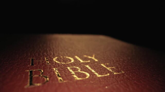 Video footage showing a close-up of the golden embossed 'Holy Bible' text slowly fading from view.