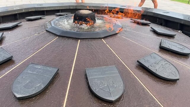 Panning shot around Centennial Flame monument fountain with fire