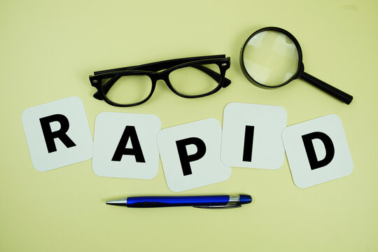 RAPID alphabet letters with magnifying glass, eye glasses and pen on yellow background
