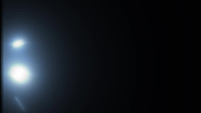 Cinematic flashing lights glow with blue stage lighting, soft circular light bursts, blinking flash and lens flare effect on black background. 4K video