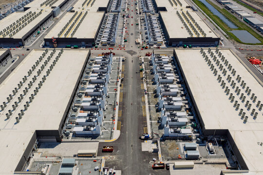Aerial view of the data center buildings, large AI center structure surrounded by cooling and power systems	