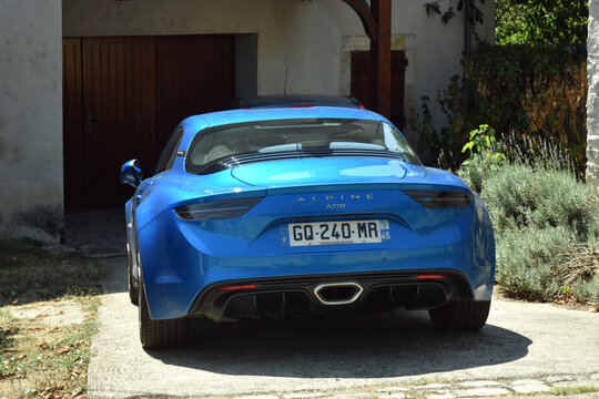 St- Amand Montrond - France - 5 August 2026 - Editorial photograph of a modern Alpine A110 sports car parked in the driveway of a private house, viewed from the rear. 