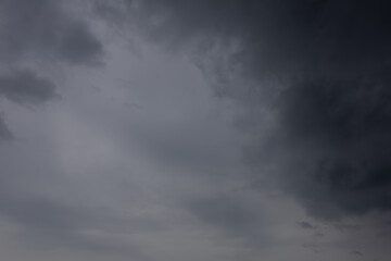 Fototapeta premium Dramatic Dark Storm Clouds Covering the Sky Before a Summer Storm. Atmospheric view of heavy dark storm clouds spreading across the sky, creating a dramatic and moody natural background. 