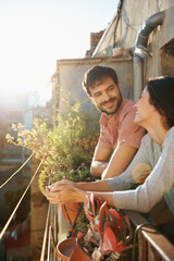 Smile, couple and relax at house on balcony, love and bonding together on calm morning. Happy, people and daydreaming on terrace for fresh air, commitment and romantic relationship for weekend break