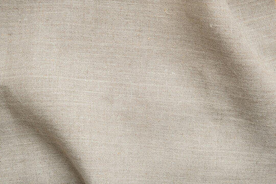Natural beige linen fabric texture with soft shadow and copy space. Organic textile background ideal for branding, skincare, packaging, lifestyle and minimalist design.