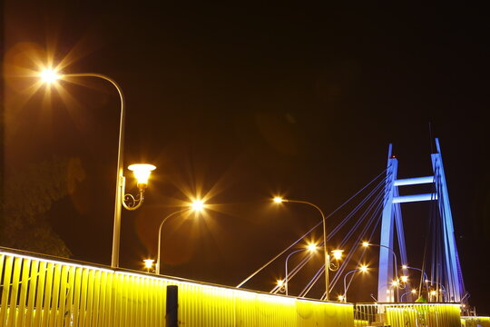 Bright streetlights illuminate a cable stayed bridge at night.