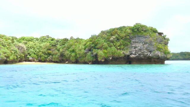The view from a boat in Kabira Bay, Ishigaki Island, Okinawa, under a cloudy sky.