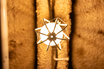 Vintage wall sconce lamp glowing in an old stone tunnel © kodai