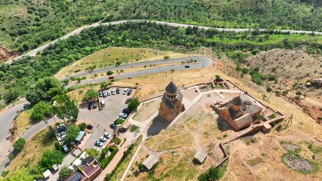 Bird's-eye shot of Noravank monastery perched on hilly landscape