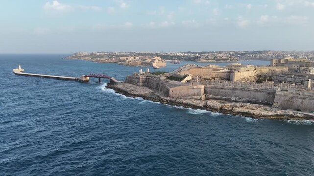 fort st elmo breakwater bridge aerial view ship distant golden hour valletta malta warm evening light coastal fortification peninsula star fort internationally recognized heritage site siege of malta