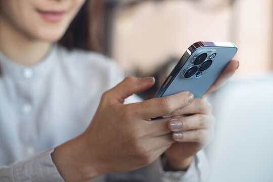 Close up of woman using smartphone browsing internet, checking social media during working in cafe, modern people lifestyle concept