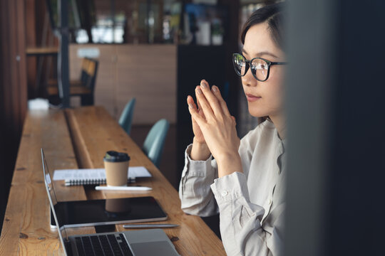 Focused business woman thinking during working on laptop with notebook on table at cafe modern workspace. Student studying online, business planning, e-learning concept