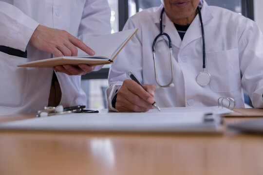 Medical team reviewing digital patient records with tablet and documents in a healthcare clinic. Doctors collaborating with health technology, electronic medical data, AI diagnostics modern clinical