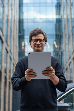 Businessman using a tablet in a modern city, confident man focus