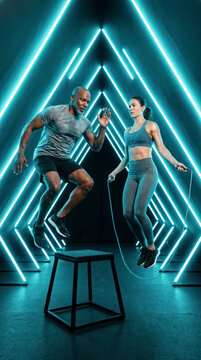 Interracial athletes jumping with rope and box in teal neon triangle studio