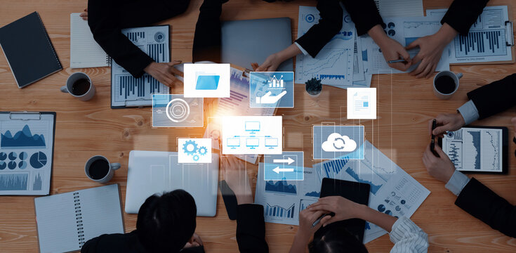 A collaborative team meeting is underway, showcasing digital interfaces and data visuals over a workspace. The focus is on strategic planning and analysis. Trope