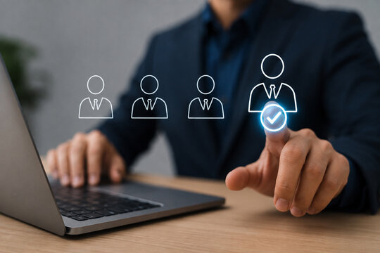 Man using a laptop and pointing at the screen, representing employee hiring, HR recruitment, job searching, staff employment, and human resources management by a recruitment agency.