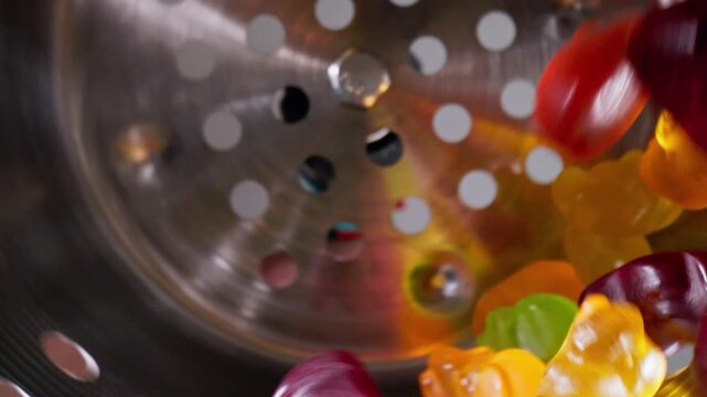 Slow motion Colorful gummy bears marmalade sweets on industrial conveyor. Food production with macro probe lens.
