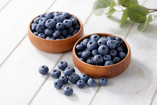 白い木目テーブルに置かれたボウルに入ったブルーベリー　Blueberries in a bowl on a white wooden table