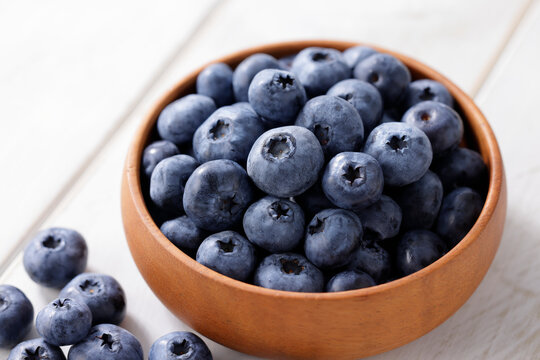 白い木目テーブルに置かれたボウルに入ったブルーベリー　Blueberries in a bowl on a white wooden table