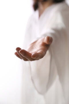 The gesture of Jesus Christ reaching out in the bright light, guiding to the path of life, Easter background
