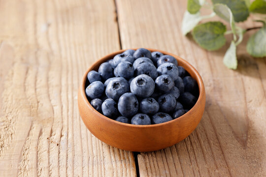 木目テーブルに置かれたボウルに入ったブルーベリー　Blueberries in a bowl on a wooden table