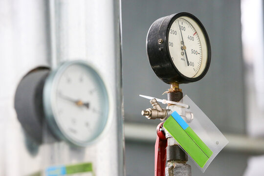 Close-up view of an industrial pressure gauge and valve on piping, essential components for monitoring and regulating critical processes within a pharmaceutical manufacturing facility Includes copy sp