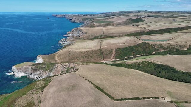 Sideways Drone Flight Along Rugged Cornish Cliffs and Coastal Farmland