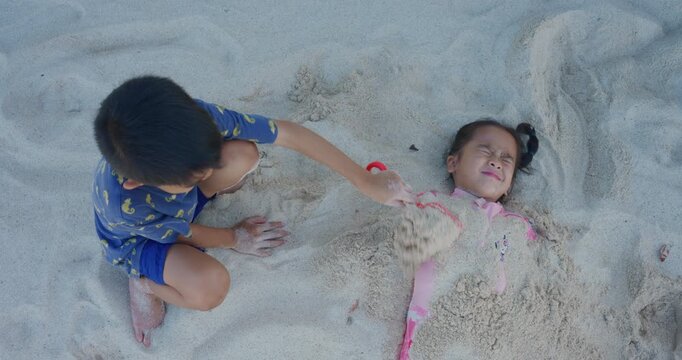 Adorable school child boy and girl enjoy play on white sand sea beach summer vacation travel