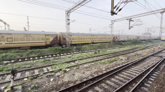 Passing Yellow Train Coaches Beside Multiple Railway Tracks